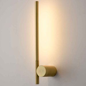 Franklite Fabula LED slimline adjustable wall light in satin brass, on grey wall, lit.