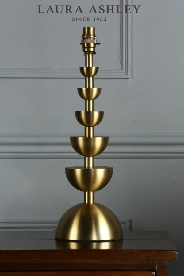 Laura Ashley Eleonore table lamp base only in aged brass, shown without shade on sideboard.