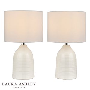 Penny cream ceramic table lamp on white background, lit.