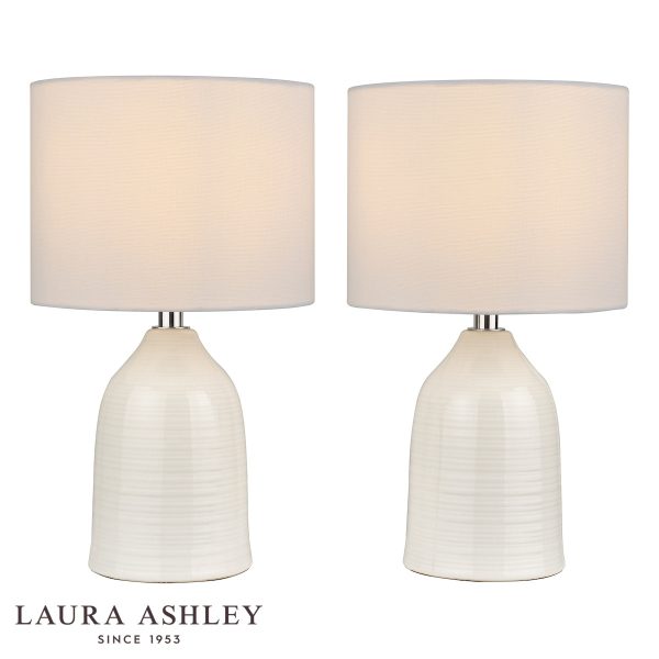 Penny cream ceramic table lamp on white background, lit.