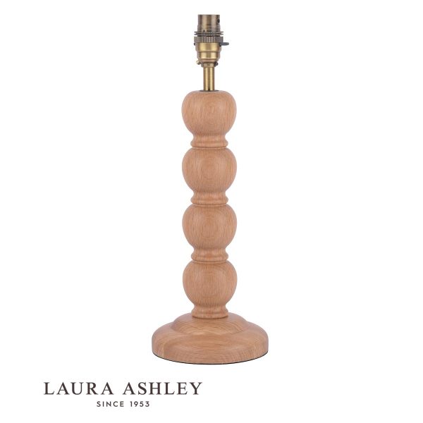 Maria oak wood candlestick table lamp with antique brass metalwork by Laura Ashley, shown without shade on white background.