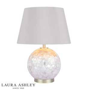 Laura Ashley Mathern mother of pearl table lamp with ivory faux silk shade, on white background, lit.