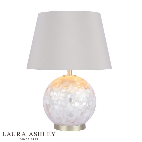 Laura Ashley Mathern mother of pearl table lamp with ivory faux silk shade, on white background, lit.