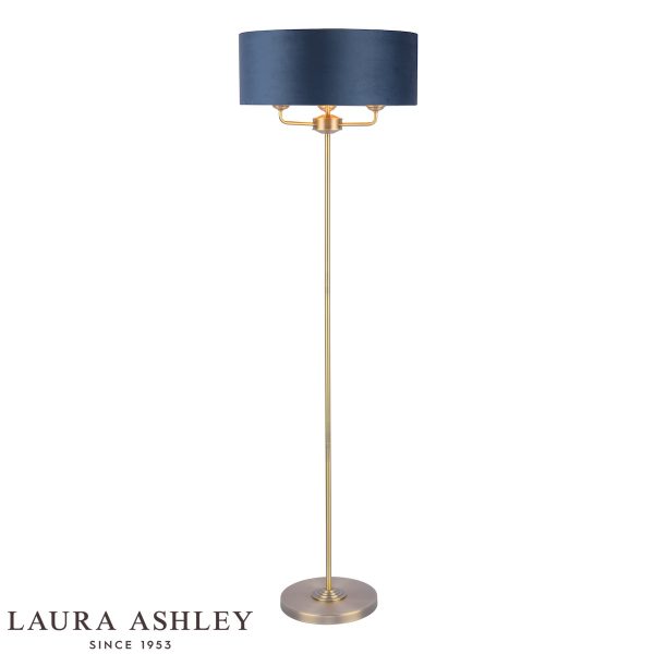 Laura Ashley Sorrento 3 light floor lamp in matt antique brass with blue velvet shade, on white background, lit.