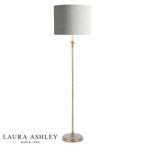 Laura Ashley Highgrove floor lamp in matt antique brass finish with grey linen shade, on white background, lit.