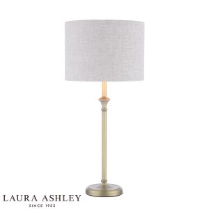 Laura Ashley Highgrove table lamp in matt antique brass finish with grey linen shade, on white background, lit.