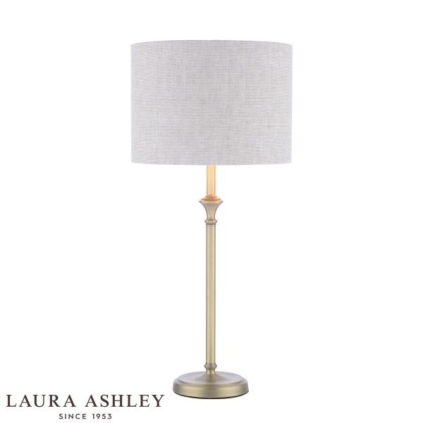 Laura Ashley Highgrove table lamp in matt antique brass finish with grey linen shade, on white background, lit.