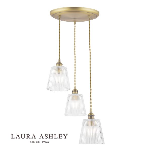 Laura Ashley Callaghan 3 light cluster pendant in antique brass on white background, lit.