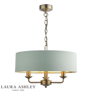 Sorrento 3 light chandelier in matt antique brass finish with green velvet drum shade, full height on white background, lit.