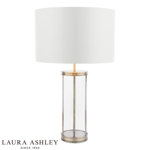 Harrington large glass table lamp in antique brass finish with ivory linen shade by Laura Ashley, on white background, lit.