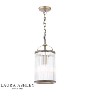 Sutton single light pendant in matt antique brass finish with clear glass rods by Laura Ashley, full height on white background, lit.