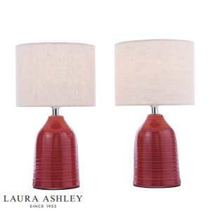 Penny red ceramic table lamp with polished chrome metalwork and ivory shade, on white background, lit.
