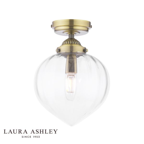 Whitham 1 light flush bathroom ceiling light in antique brass finish, on white background, lit.