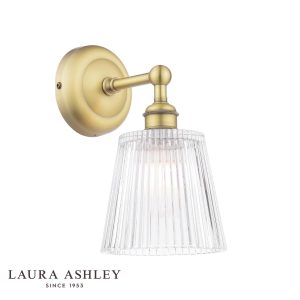 Callaghan bathroom wall light in matt antique brass finish with clear ribbed glass shade by Laura Ashley, shown with logo on white background.