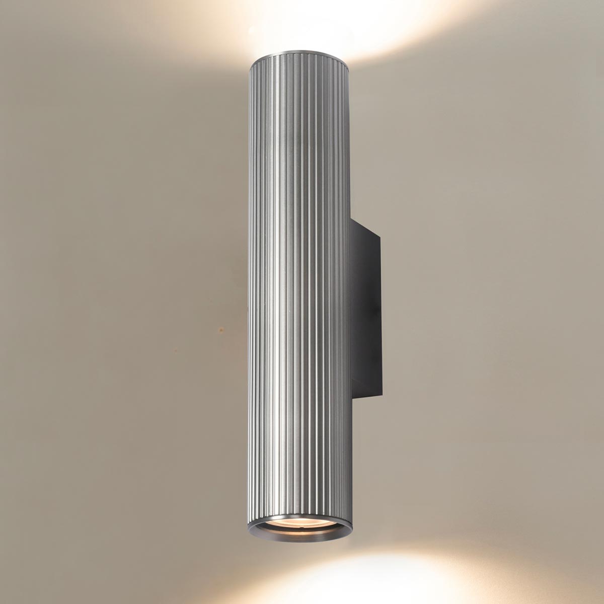 Franklite Scout modern up and down wall light in satin nickel, on cream background, lit.