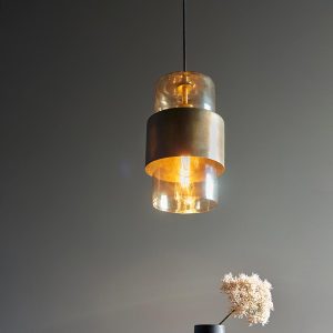 Classic aged brass patina single light pendant with champagne glass shade over table