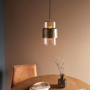 Classic aged bronze patina single light pendant with clear glass shade over table