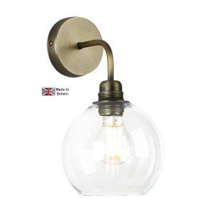 Apollo 1 light solid antique brass wall light with clear glass shade on white background lit