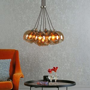 Apollo 7 light cluster pendant in solid butter brass with opal glass shades shown over lounge table