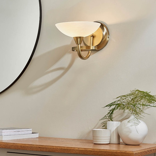 Cagney wall light in antique brass, shown fitted above a hall console table.
