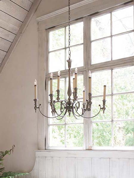 Image of 8 light chandelier with tall candle tubes fitted high with window background