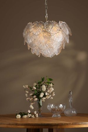 Courtney 10 light pendant in antique brass with textured glass leaves, over dining room table lit