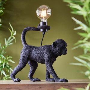 Capuchin monkey table lamp figurine in matt black on room sideboard