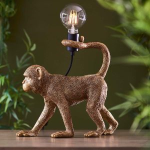 Capuchin monkey table lamp figurine in vintage gold on room sideboard