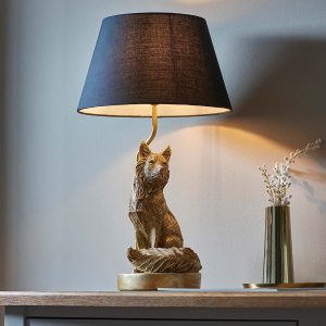 Fox table lamp figurine in vintage gold with black shade on sideboard in room setting