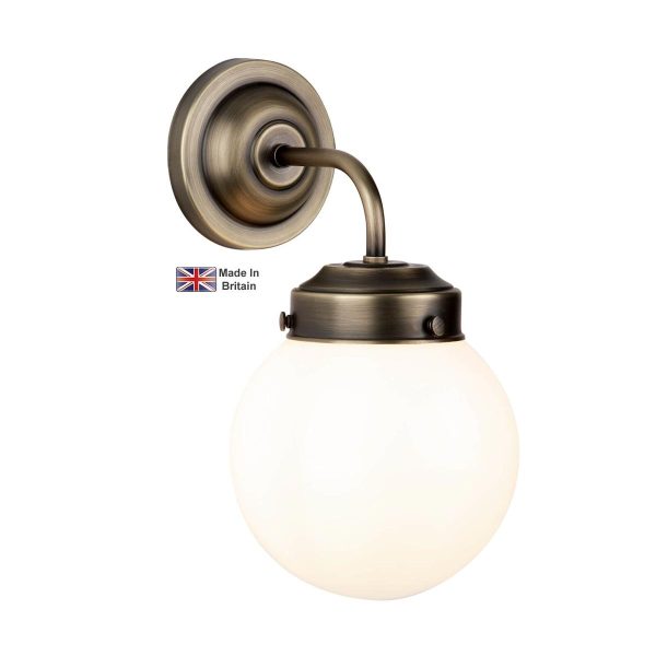 Fairfax single wall light in solid antique brass with opal white glass shade on white background lit