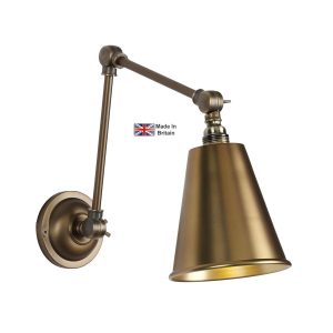 Hackney swing arm wall light in antique brass on white background lit