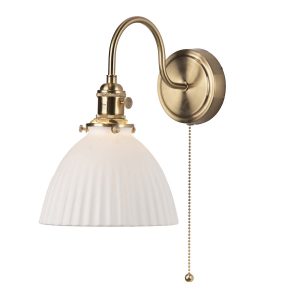 Hadano switched wall light in natural brass with domed white ceramic shade on white background lit