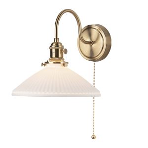 Hadano switched wall light in natural brass with white ceramic coolie shade on white background lit