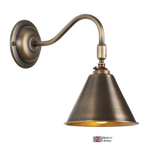 London classic adjustable wall light in solid antique brass on white background lit