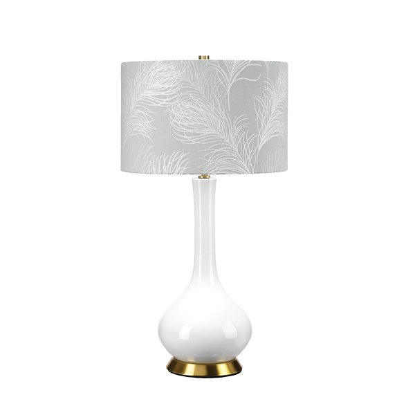 Milo white ceramic table lamp with aged brass metalwork and duck egg feather shade, on white background, lit.
