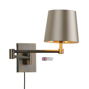 Muswell swing arm plug in wall light in solid antique brass on white background lit
