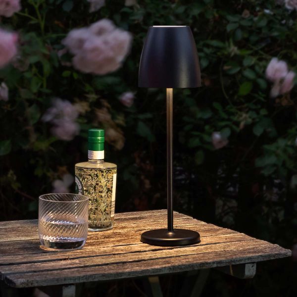Lyle rechargeable LED outdoor table lamp in matt black, shown at dusk on patio table