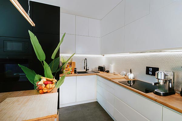 Modern kitchen with LED under cupboard lights illuminating the worktop.
