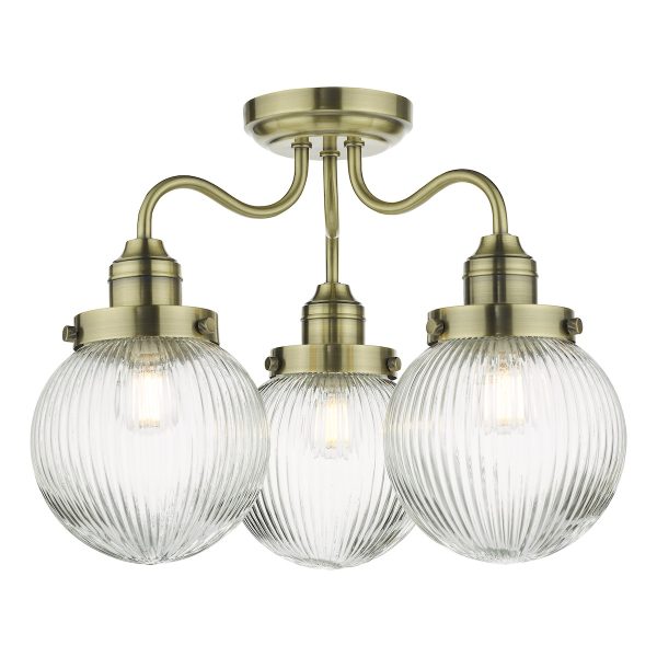 Tamara 3 arm bathroom semi flush light in antique brass with ribbed glass shades on white background lit