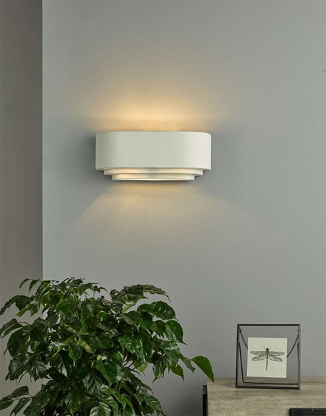 Lando up and down wall washer light, shown lit in a living room setting.